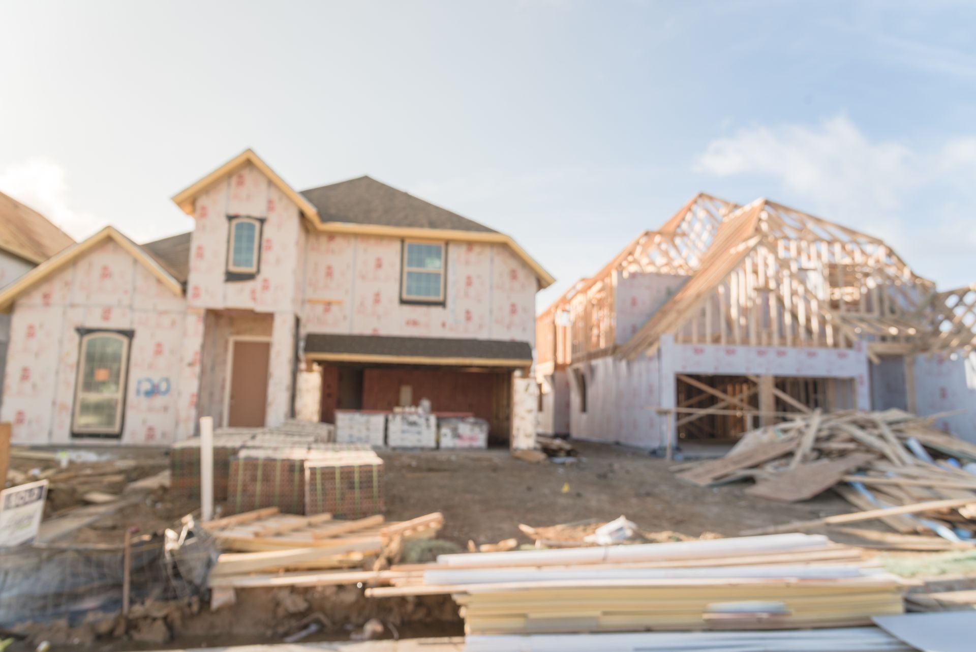 Blurred abstract row of wood frame house under construction in suburban Irving, Texas, USA. New stick built 2 floor and almost completed home wall covered by panels, sheathing, envelope sealing Blurred abstract row of wood frame house under construction in suburban Irving, Texas, USA. New stick built 2 floor and almost completed home wall covered by panels, sheathing, envelope sealing
